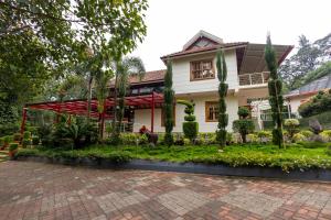 ein Haus mit Garten davor in der Unterkunft Honeydewwz Exoticaa Hotel & Resort in Chikmagalur