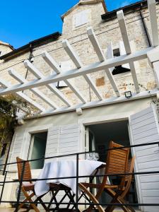 eine Terrasse mit 2 Stühlen und einem Tisch auf dem Balkon in der Unterkunft House called Happiness in Jelsa