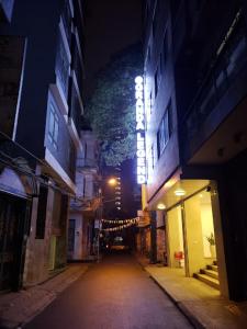 ulica miejska w nocy z oświetlonym znakiem w obiekcie Granda Legend Apartment w mieście Hanoi