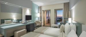 a hotel room with a bedroom with a bed and a desk at Arcanus Hotels Sorgun - Ultra All Inclusive in Side