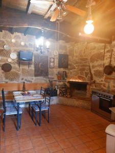 a room with a table and chairs and a fireplace at CASA A ESCOLA in Piñeiro +2 photos