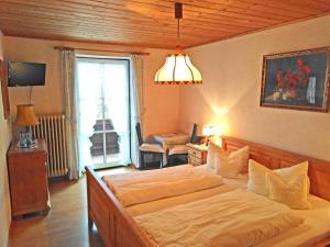 sypialnia z dużym łóżkiem i dużym oknem w obiekcie Pension Brucker w mieście Aschau im Chiemgau