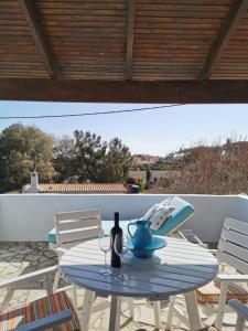 una mesa con una botella de vino en el patio en Villa Christina, en Karfas