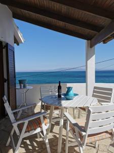 una mesa y sillas en un patio con vistas al océano en Villa Christina, en Karfas