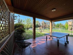 un tavolo da ping pong su una veranda con vista sul parco di Villanova 4 Rooms a Villanova