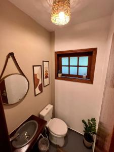 a bathroom with a toilet and a sink and a mirror at Dimare Búzios - Casa Exclusiva no Centro - Próximo à Rua das Pedras in Búzios