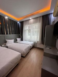 a hotel room with two beds and a television at Crowned Plus Hotel in Istanbul