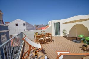 balkon ze stołem, krzesłami i parasolem w obiekcie Central & Stylish 2 Bedroom Apartment w/ Balcony w mieście Cascais