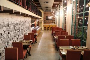 Un restaurante con mesas y sillas y dibujos en la pared. en Rosetum Anjuna Goa, en Anjuna