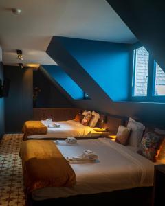 two beds in a room with a blue ceiling at Gran Hotel De Passage in Bruges