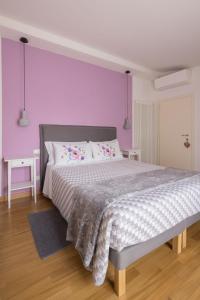 - une chambre avec un grand lit aux murs violets dans l'établissement La Ghirlanda B&B, à Arezzo