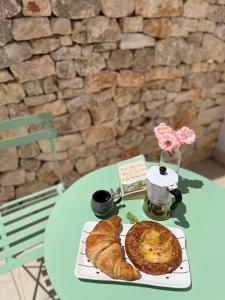 a table with a plate of pastries and a cup of coffee at Donna Silvia Apartments in Castellana Grotte