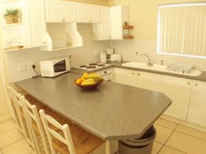 a kitchen with a bowl of fruit on a counter at Point Village Accommodation - Snowdove in Mossel Bay +9 photos