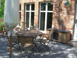 a patio with a table and chairs and a fireplace at Bauernkate Seerose in Rankwitz