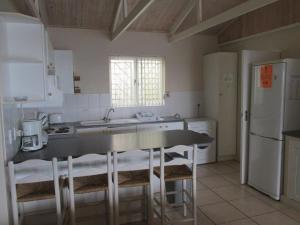 a kitchen with a counter and a sink and a refrigerator at Point Village Accommodation - Snowdove in Mossel Bay