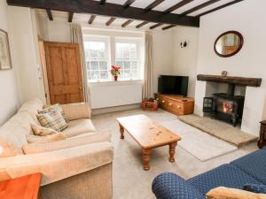a living room with a couch and a fireplace at Cherry Tree Cottage in Bingley