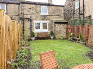 a backyard with a bench and a fence at Cherry Tree Cottage in Bingley