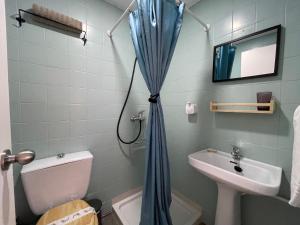 baño con cortina de ducha azul y lavamanos en PENSION SOCAIRE CONIL, en Conil de la Frontera