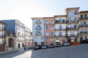 a city street with cars parked in front of buildings at Tripas Coração Taipas Historical Center in Porto