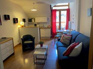 ein Wohnzimmer mit einer blauen Couch und einer Küche in der Unterkunft Studio 4 pers avec balcon sud et WIFI, Brides-les-Bains - FR-1-512-135 in Brides-les-Bains