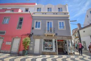 a building on a street with people walking around it at Charming Seaside Apartment - 1 min from the beach in Cascais