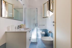 een badkamer met een toilet, een wastafel en een douche bij House Zia Fiume by BarbarHouse in Tuglie