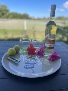 a plate with a bottle of alcohol and flowers on a table at Bungalow de Rose in Petit-Canal +7 photos