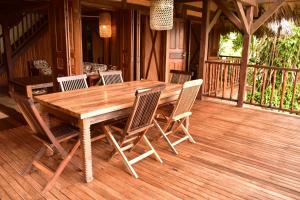 una mesa de madera y sillas en una terraza en LOCAVACATION Les Hauts Manguiers Villa 2 en Nosy Be