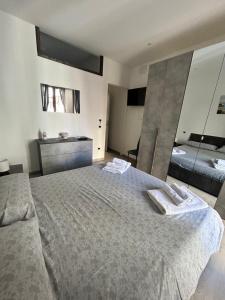 une chambre avec un grand lit avec deux serviettes dessus dans l'établissement Casa Marina, La Terrazza Sul Mare, à Cefalù