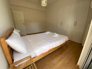 um pequeno quarto com uma cama e armários brancos em Luxury apartment close to Glyfada beach em Atenas
