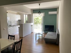 een keuken en een woonkamer met een bank en een tafel bij Luxury apartment close to Glyfada beach in Athene