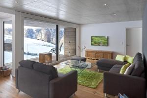 una sala de estar con 2 sofás y una ventana grande en Sera Lodge, en Grächen