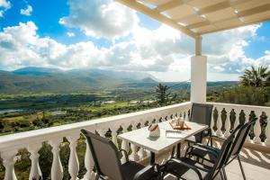 een tafel en stoelen op een balkon met uitzicht op de bergen bij Nikos Apartments Spacious and Panoramic in Argostoli