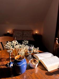 a wooden table topped with a book and a glass at Bezkresne- Domy w Sidorach in Jeleniewo