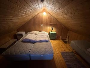 a bedroom with a bed in a wooden room at Handkleppveien 26 - Fishermans cabin in Straume