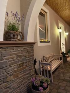 a porch with a bench and flowers and a window at NEU!!! Moselbleibe Winzerhaus Kues in Bernkastel-Kues