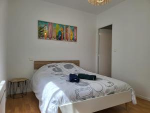 a bedroom with a bed with a painting on the wall at le T2 d'henri in Agen