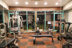 un gimnasio con máquinas de correr y espejos en una habitación en Rosetum Anjuna Goa, en Anjuna