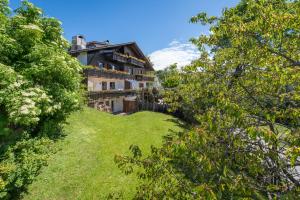 una casa su una collina con un giardino verde di Garni-Residence Villa Paul a Nova Ponente