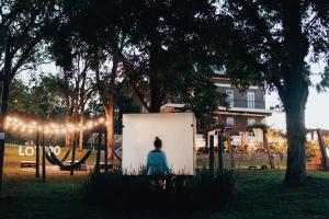 a woman sitting on a bench in a park at LOTE20 Hotel Boutique in Bento Gonçalves