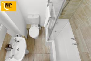 a white bathroom with a toilet and a sink at Baxter Park - City Base in Dundee