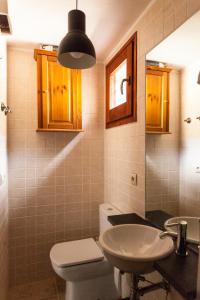 uma casa de banho com um WC branco e um lavatório. em Casa rústica la Borda de la Munda. em Arsèguel