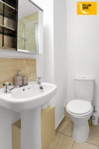 uma casa de banho com um lavatório branco e um WC. em Baxter Park - City Base em Dundee
