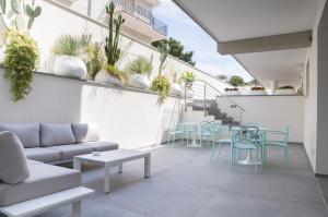 een woonkamer met een bank, stoelen en planten bij Galileo Suite in Trani