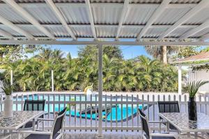 a patio with tables and chairs and a swimming pool at Modern Villa with Pool Hollywood Hard Rock Casino in Fort Lauderdale