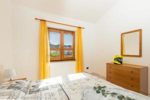 ein Schlafzimmer mit einem Bett und einem Fenster in der Unterkunft Casa a due passi dal mare in Àrbatax