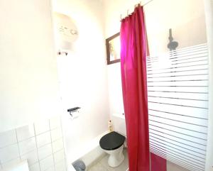 uma casa de banho com um WC e uma cortina de chuveiro vermelha. em Appartement d'une chambre a Saint Cyprien Plage a 150 m de la plage avec terrasse et wifi em Saint-Cyprien-Plage