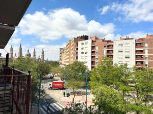 a view of a city with tall buildings and a red truck at Dos Torres Rivendel - Vistas a la Basílica del Pilar in Zaragoza