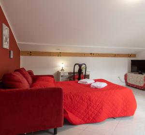 ヴィエトリにあるbb Al Centro Di Vietriのベッドルーム(赤いベッド1台、赤いソファ付)