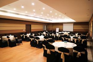 Un salón de banquetes con mesas y sillas y una pantalla. en Rosetum Anjuna Goa, en Anjuna 40 fotos más